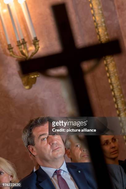 June 2018, Germany, Munich: Markus Soeder , Premier of Bavaria, sitting behind a cross during the swearing-in ceremony of the 89th bishop of...