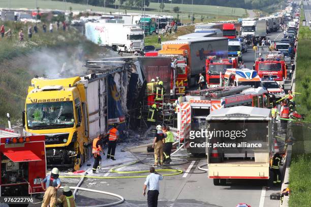 June 2018, Germany, Schleiz: Firefighters working on a burning truck along the Autobahn 9 near Schleiz in the Saale-Orla district. A total of four...