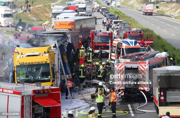 June 2018, Germany, Schleiz: Firefighters working on a burning truck along the Autobahn 9 near Schleiz in the Saale-Orla district. A total of four...