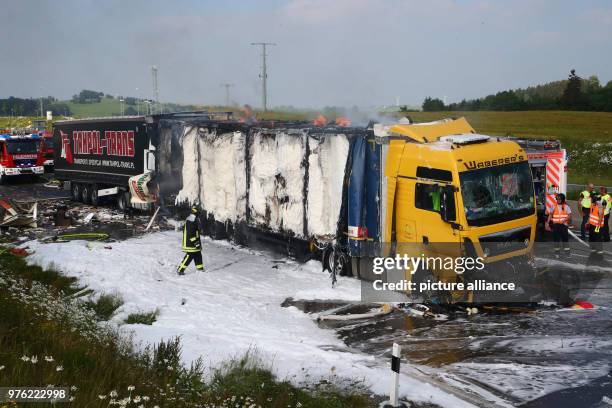 June 2018, Germany, Schleiz: Firefighters working on a burning truck along the Autobahn 9 near Schleiz in the Saale-Orla district. A total of four...