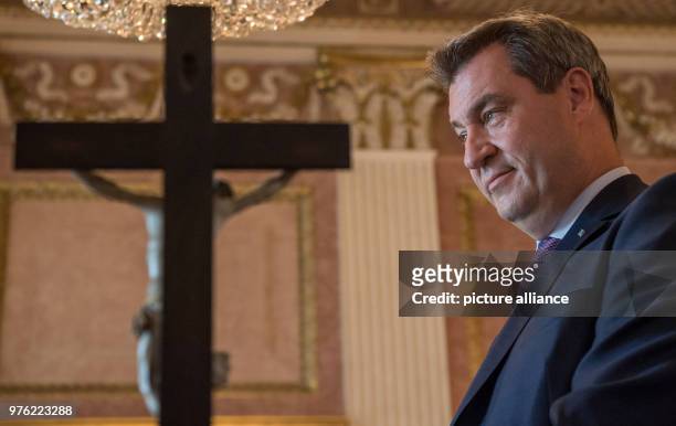 June 2018, Germany, Munich: Markus Soeder , Premier of Bavaria, standing behind a cross during the swearing-in ceremony of the 89th bishop of...