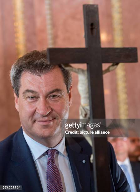 June 2018, Germany, Munich: Markus Soeder , Premier of Bavaria, standing behind a cross during the swearing-in ceremony of the 89th bishop of...