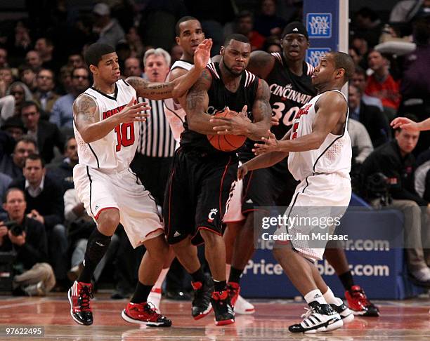 Deonta Vaughn of the Cincinnati Bearcats fights for the ball with Edgar Sosa and Preston Knowles of the Louisville Cardinals during the second round...