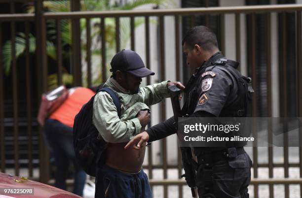 June 2018, Brazil, Rio De Janeiro: A police officer performing a body search during a deployment in the Babilonia favela. Security units are tracking...