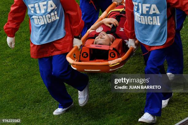 Denmark's midfielder William Kvist is stretchered off the pitch with an injury during the Russia 2018 World Cup Group C football match between Peru...