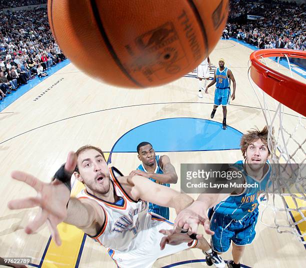 Nenad Krstic of the Oklahoma City Thunder goes to the basket against Aaron Gray of the New Orleans Hornets on March 10, 2010 at the Ford Center in...