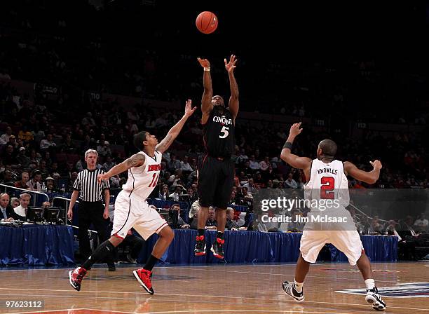 Deonta Vaughn of the Cincinnati Bearcats shoots over Edgar Sosa and Preston Knowles of the Louisville Cardinals during the second round of 2010 NCAA...