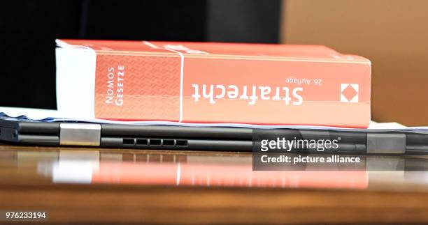 June 2018, Germany, Freiburg: A book of the criminal law lying on the table of an associate judge lying on a table during the trial against the...
