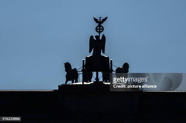 June 2018, Germany, Berlin: The Quadriga on the Brandenburg Gate with the backlight of the sun. - NO WIRE SERVICE - Photo: Paul Zinken/dpa