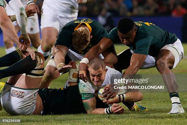 England fullback Mike Brown holds on to the ball as South Africa's wing S'busiso Nkosi and South Africa's loose head prop Steven Kitshoff try to...
