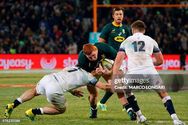 South Africa's loose head prop Steven Kitshoff is tackled by England prop Mako Vunipola during the second test match South Africa vs England at the...