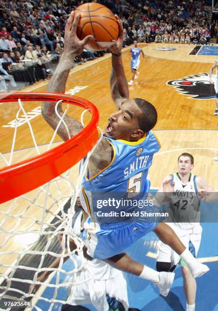 Smith of the Denver Nuggets dunks against Corey Brewer and Kevin Love of the Minnesota Timberwolves during the game on March 10, 2010 at the Target...