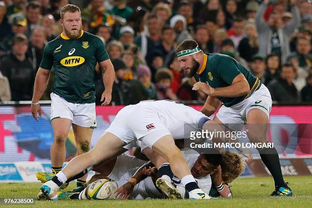 England's prop Mako Vunipola protects the ball while in a ruck, as South Africa's tight head prop Thomas du Toit and South Africa hooker Akker van...