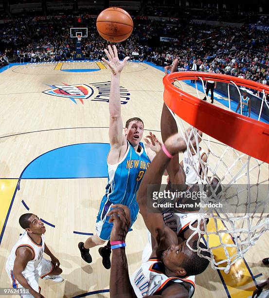 Darius Songaila of the New Orleans Hornets shoots over Serge Ibaka of the Oklahoma City Thunder on March 10, 2010 at the Ford Center in Oklahoma...