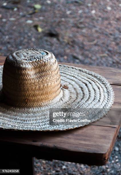 old straw hat on wood bench - straw hat stock pictures, royalty-free photos & images