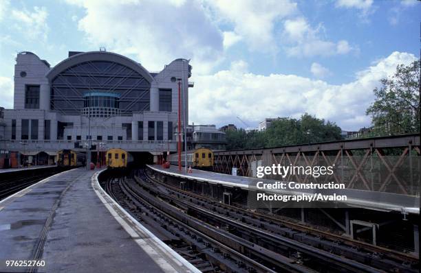 Platform view of Charing Cross station, London showing the distinctive architectural style of the main building and suburban commuter trains at the...