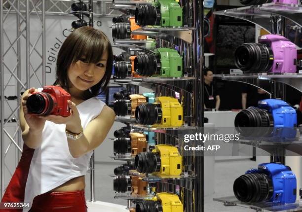 Representative of Japan's optical maker Hoya displays a colorful single-lens-reflex digital camera "Pentax K-x", available in twenty different...