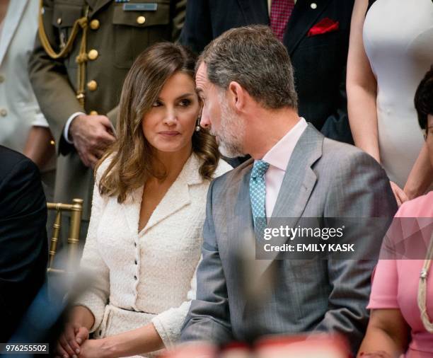 King Felipe VI whispers to Queen Letizia of Spain as they listen to traditional New Orleans brass music as part of the city's Tricentennial...