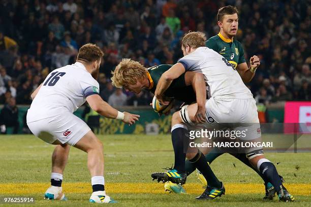South Africa's flanker Pieter-Steph du Toit is tackled by England's lock Joe Launchbury during the second test match between South Africa and England...