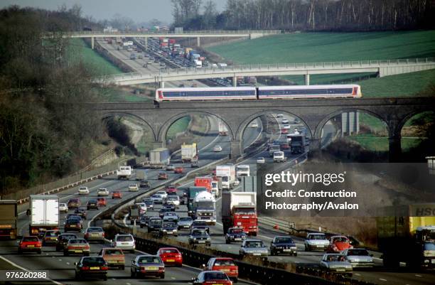 Chiltern Trains DMU glides gracefully over the congested traffic on the M25 motorway, circa 1993.