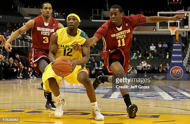 Tajuan Porter of the Oregon Ducks drives to the basket while being pursued by Xaiver Thames of the Washington State Cougars in the second half during...