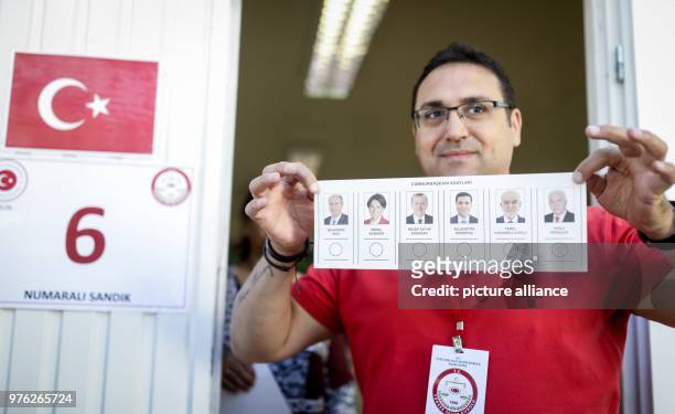 June 2018, Berlin, Germany: An election worker presents the ballot slip at the Turkish general consulate in front of a polling station. Turkish...