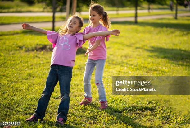 zwillingsschwestern spielen in der natur - trusting stock-fotos und bilder