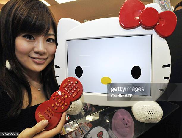 Sanrio employee displays the new 13.3-inch sized LCD television shaped as a face of character 'Hello Kitty' in Tokyo on March 1 expected to go on the...