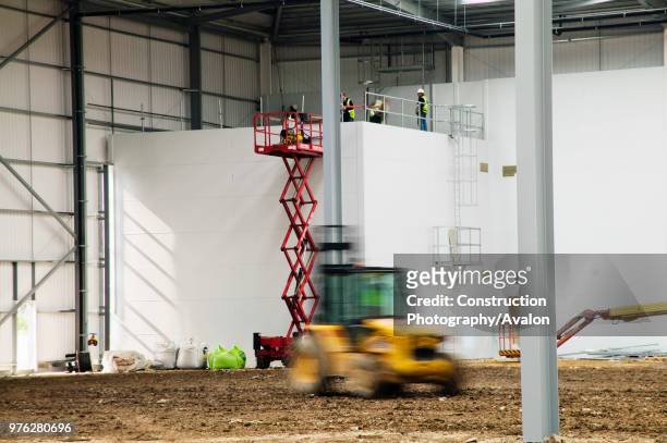 Men at work on interior of warehouse, Hemel Hempstead, Hertfordshire, UK.