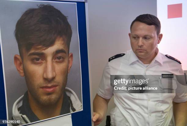 June 2018, Wiesbaden, Germany: A policeman fastens a partition with the wanted police photo of the wanted Ali Bashar. The 20-year-old Iraqi is the...