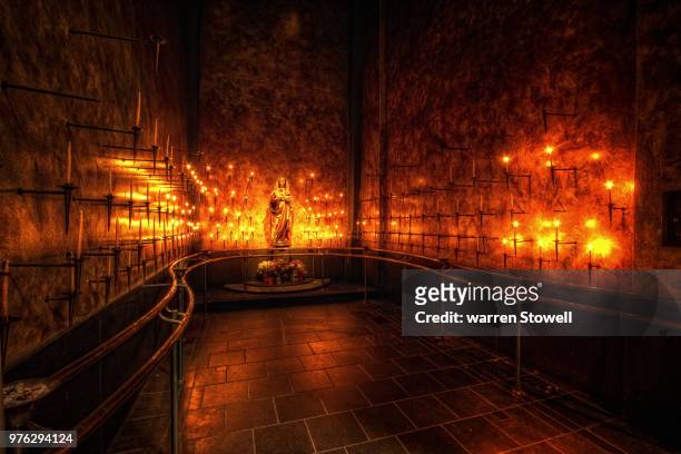 candles on walls around virgin mary statue - mary moody stock-fotos und bilder