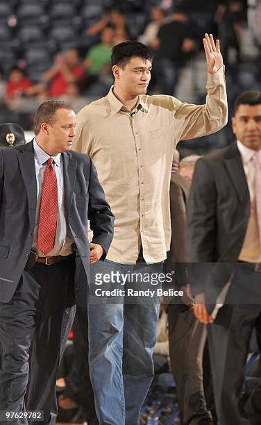 Yao Ming of the Houston Rockets acknowledges fans while in the company of team CEO Tad Brown during the NBA D-League game between the Austin Toros...