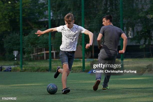 Teenagers play football in a 'korobka' next to their high rise tenement homes in the Moscow suburb of Timiryazevskaya on June 16, 2018 in Moscow,...