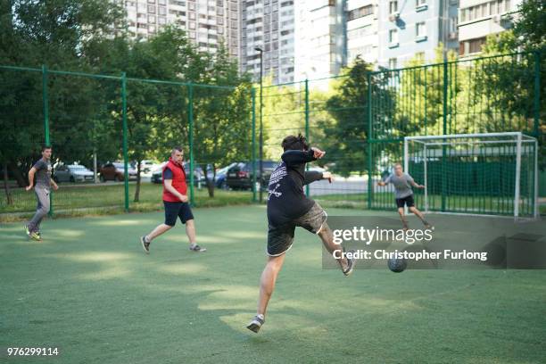 Teenagers play football in a 'korobka' next to their high rise tenement homes in the Moscow suburb of Timiryazevskaya on June 16, 2018 in Moscow,...