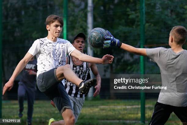 Teenagers play football in a 'korobka' next to their high rise tenement homes in the Moscow suburb of Timiryazevskaya on June 16, 2018 in Moscow,...