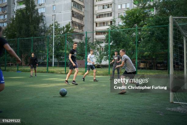 Teenagers play football in a 'korobka' next to their high rise tenement homes in the Moscow suburb of Timiryazevskaya on June 16, 2018 in Moscow,...