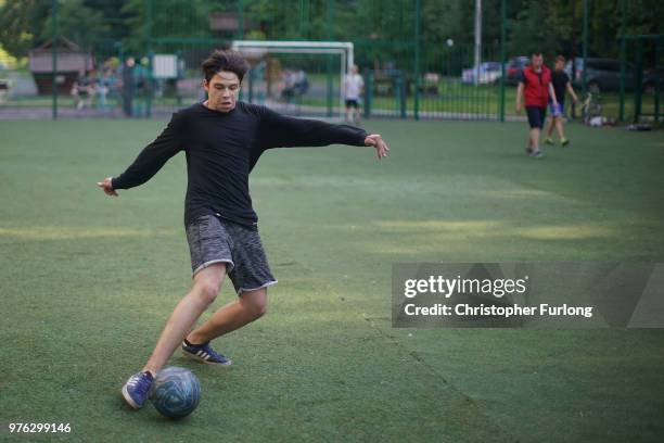 Teenagers play football in a 'korobka' next to their high rise tenement homes in the Moscow suburb of Timiryazevskaya on June 16, 2018 in Moscow,...