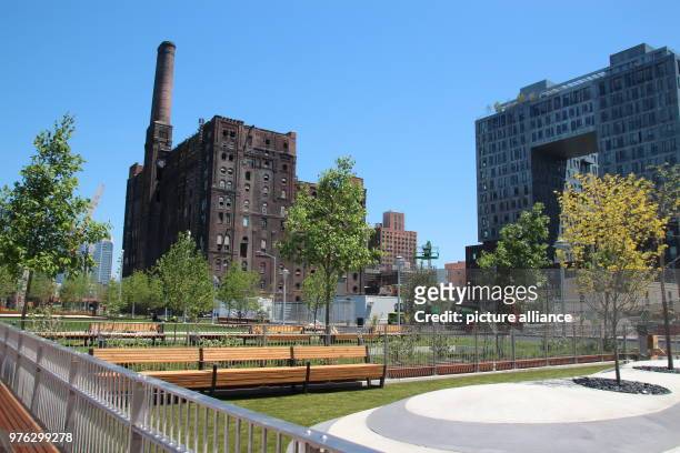 May 2018, USA, New York: The building of the former Domino Sugar Factory refinery in the newly built Domino Park beside a new luxury housing complex....