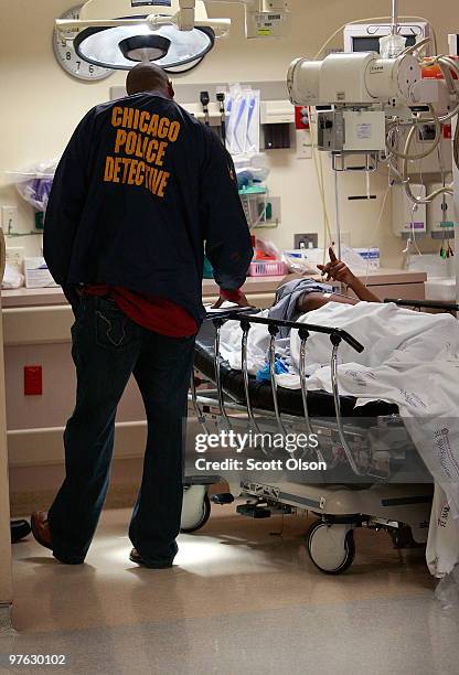 Chicago police detective questions a person brought into the Trauma Unit at the John H. Stroger Jr. Cook County Hospital with a gunshot wound...