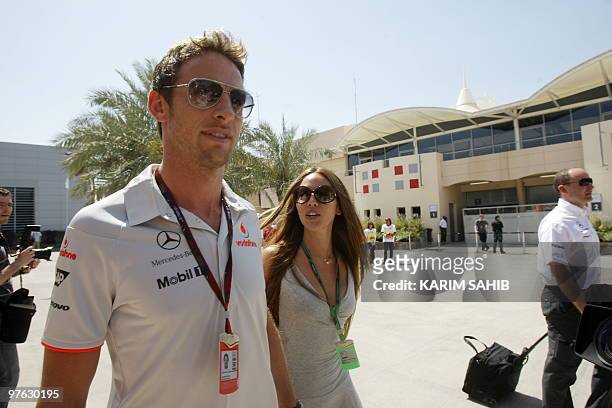 McLaren Mercedes' British driver Jenson Button and his girlfriend Jessica Michibata walk in the paddock of the Bahrain international circuit on March...