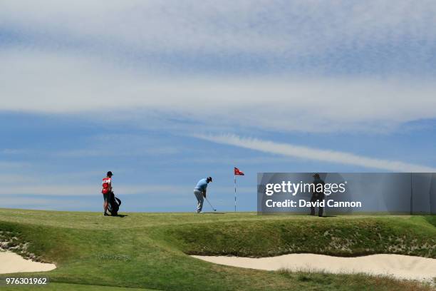 Andrew Johnston of England plays his second shot on the 11th green watched by Phil Mickelson of the United States during the third round of the 2018...