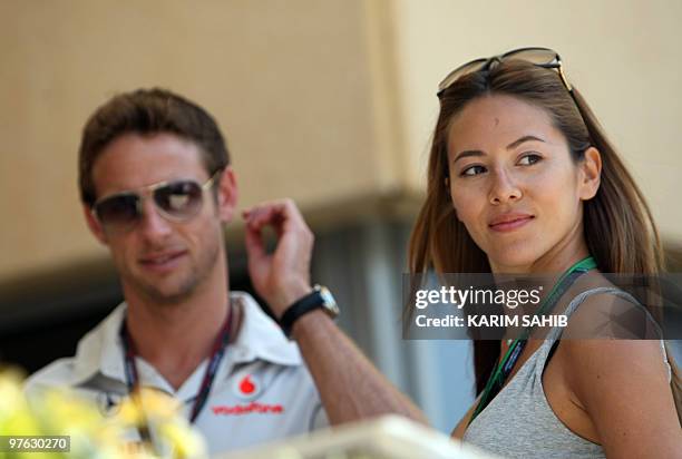 McLaren Mercedes' British driver Jenson Button and his girlfriend Jessica Michibata are pictured in the paddock of the Bahrain international circuit...