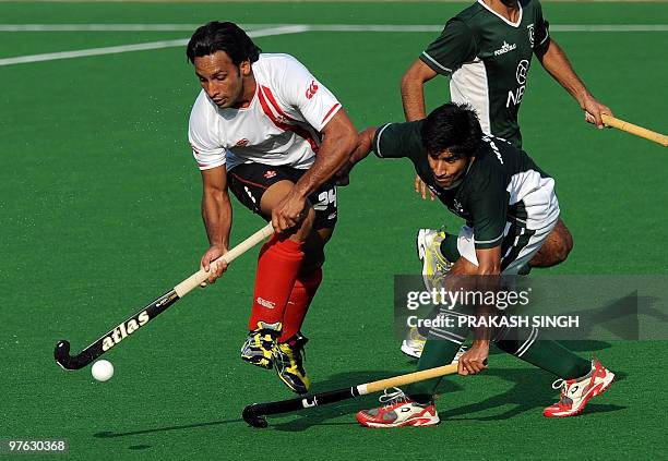 Canadian hockey player Gabbar Singh in action against Pakistan's Waseem Ahmed during their World Cup 2010 match for 11th and 12th place at the Major...