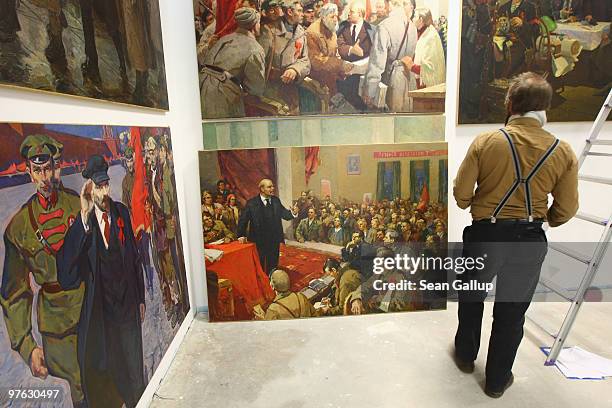 Worker hangs paintings featuring early-19th century Russian revolutionary leader Vladimir Lenin ahead of the "Behind The Iron Curtain - Art Of...