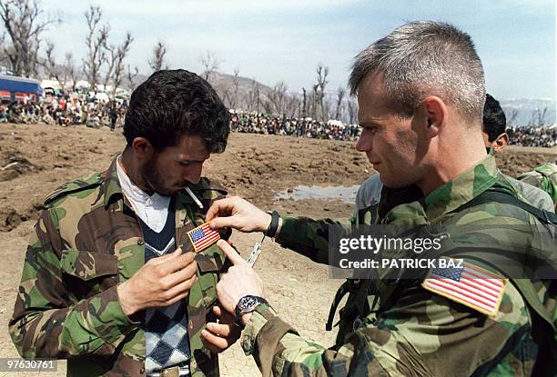 Special Forces Sgt. Sticks 21 April 1991 near Cirze on Iraq-Turkey border a US flag on the jacket of an Iraqi soldier who fled from the Iraqi army in...