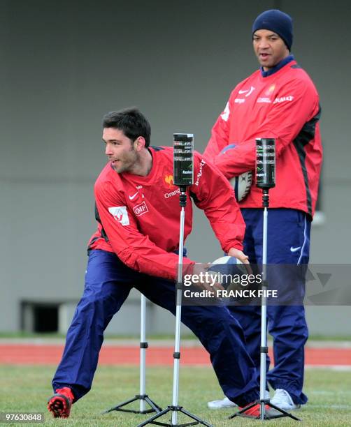 France's rugby union national team scrum-half Dimitri Yachvili practices in front French national rugby union team coach assistant coach Emile...