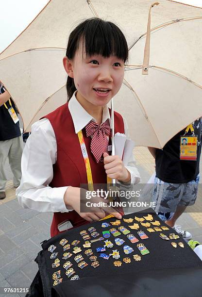 Chinese woman displays her collection of pins to be traded with visitors outside the main press centre ahead of the 2008 Beijing Olympic Games in...
