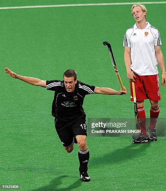 England's hockey player Alastair Wilson watches as German hockey player Oliver Korn celebrates his team's second goal during their World Cup 2010...