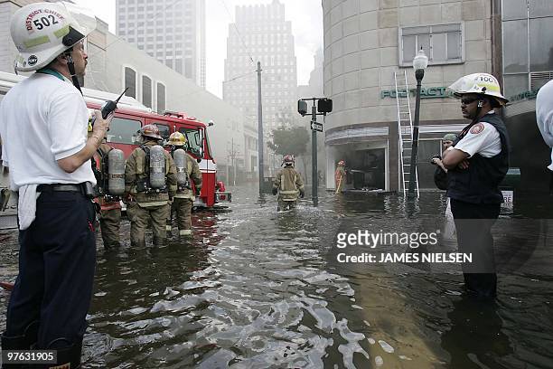 New Orleans Fire Department firefighters work a blaze despite the high flood waters 31 August 2005 at an athletic footware store that was looted in...