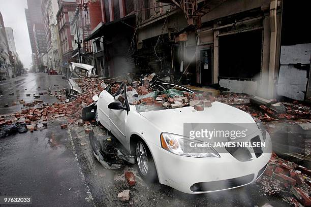 Cars sit along a side street damaged by falling debris in the French quarter of New Orleans, 29 August 2005, as Hurricane Katrina makes landfall....